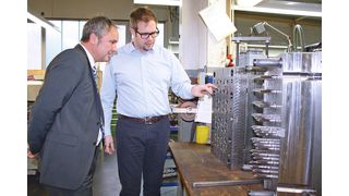 Problem-Werkzeug: Geschäftsführer Sascha Möhs (re.) zeigt Andreas Zwiener, Vertriebsingenieur bei Sumitomo (SHI) Demag, das 32-fach-Werkzeug, bei dem die Füllung aller Kavitäten auf elektrischen Maschinen in der Vergangenheit Sorgen bereitete. (Bild: Sumitomo (SHI) Demag)