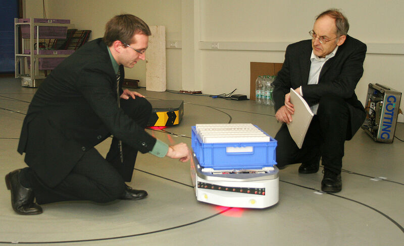 Dr. Sebastian Behling (links) und Hans-Heinrich Götting mit „KATE“. Die „kleine automatischeTransport-Einheit“ wurde von der Lehrter Firma Götting entwickelt. Im Forschungsprojekt „FTF out of the box“ soll sie Sehen, Hören und Denken lernen. (Bild: IPH)