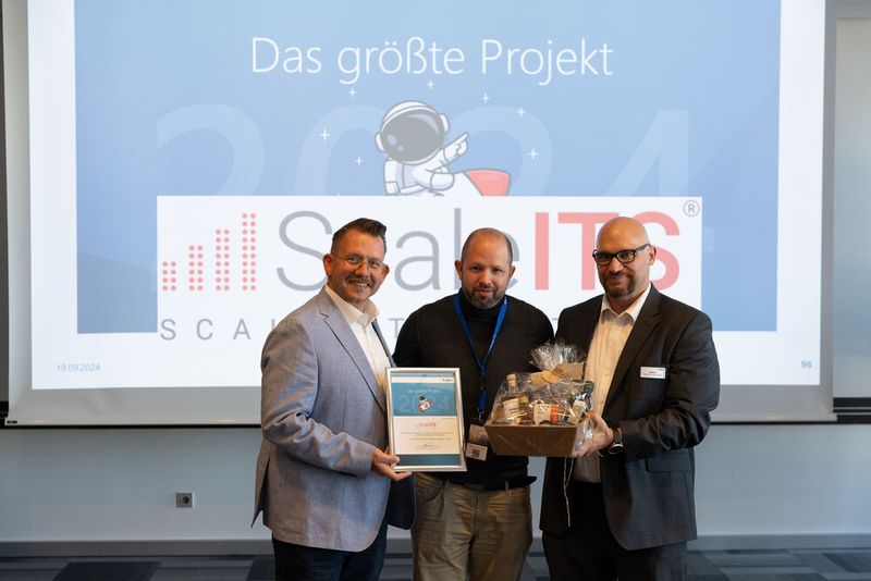 Die Auszeichnung für das größte Projekt: Sascha Kaiser und Markus Benker (beide Aagon GmbH) gratulieren Patrick Hack (m., ScaleITS). (Bild: Aagon GmbH)
