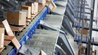 Die Endsortierung: Über Rutschen werden die Kartons dem Crisplant LS-4000CB Cross-Belt-Sorter zugeführt. (Bild: Beumer)