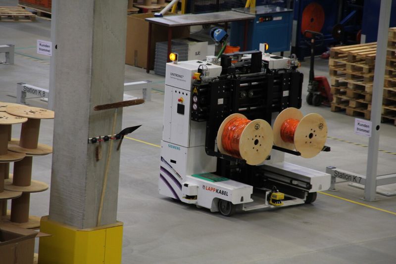 Zwölf fahrerlose Transportsysteme bringen die Kabeltrommeln zur Ablängerei, wo von den Mitarbeitern pro Stunde bis zu 150 Trommeln bearbeitet werden können. (Bild: Schäfer)