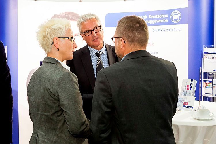 Die Bank Deutsches Kraftfahrzeuggewerbe (BDK) trat auf der Fachtagung als Sponsor auf. Klaus-Dieter Ixmeier (Mitte) erklärte den Teilnehmern die Neuheiten aus dem Finanzsektor. (Foto: Bausewein)