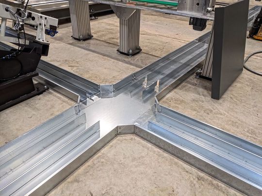 An den Knotenpunkten zwischen den Robotern hat MJ-Gerüst Kanalkreuzungen montiert, in denen Energie-, Daten- und Pneumatik-Leitungen getrennt geführt werden. (Bild:  Lutz/Pflitsch)