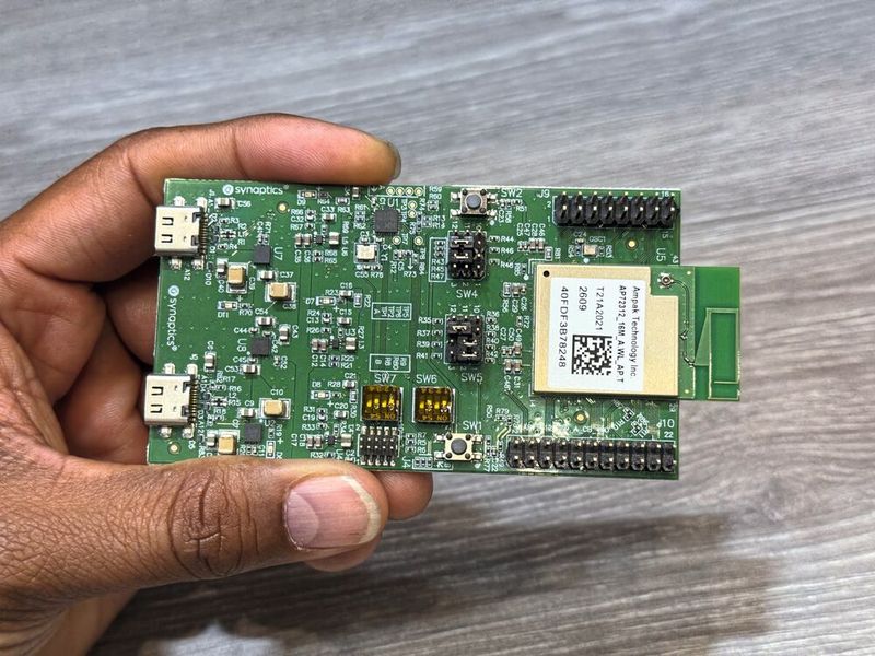 Detailaufnahme des Evaluation-Kits für den neuen SYN765x-Chip. Dieses Entwickler-Board ist das Herzstück der Smart-Home-Demonstration rund um die intelligente Mikrowelle. Ausgestattet mit einem aufgesetzten Ampak-Funkmodul samt Antenne, USB-C-Ports und weiteren Entwickler-Schnittstellen, übernimmt die Platine autark KI-Sensorik-Aufgaben sowie die Steuerung als IoT-Hub für Standards wie Wifi 7, Thread und Matter. (Bild: mc/VCG)