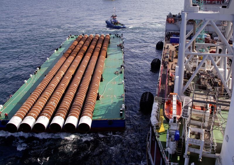Über 100 Mitarbeiter begleiten die Installation auf hoher See. Neben den bis zu 100 Meter langen Stahlpfeilern, die einen Durchmesser von bis zu 3,2 Metern und eine Wandstärke von acht Zentimetern erreichen, sind die Mitarbeiter (vorne links im Bild) kaum zu erkennen. (Siemens)
