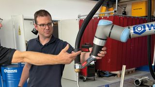 WEMAG-Geschäftsführer Christopher Schaus präsentiert einen Cobot (Quelle: WEMAG GmbH & Co. KG)