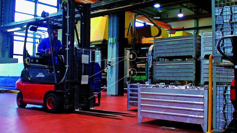 Bild 1: Am Gabelstapler schaltet ein Ultraschall-Abstandssensor (1), der zwischen den Gabelzinken angebracht ist, die RFID-Lesegeräte und damit die beiden UHF-Antennen (2) zum Erfassen der Transponder ein. (Archiv: Vogel Business Media)