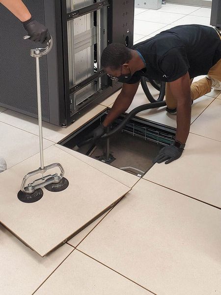 Abbildung 7: Unerschrocken - Zur gründlichen Reinigung von Rechenzentrumsräumen macht das fachlich geschulte Reinigungspersonal auch vor Doppelbodenplatten keinen Halt. (Bild: Keding Computer-Service)