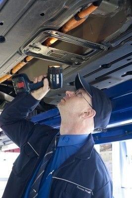 TÜV SÜD Prüfingenieur Thomas Praßüberprüft im Rahmen der Hauptuntersuchung den Zustand der Kabelführungen des Mini E. (Bild: TÜV SÜD)
