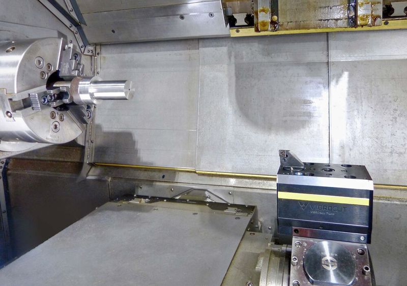 A Vibrocut toolholder mounted in a driven station of a lathe turret. It delivers reciprocating motion to a static cutting tool to promote chipbreaking. (Source: Nydaloxe Precision )