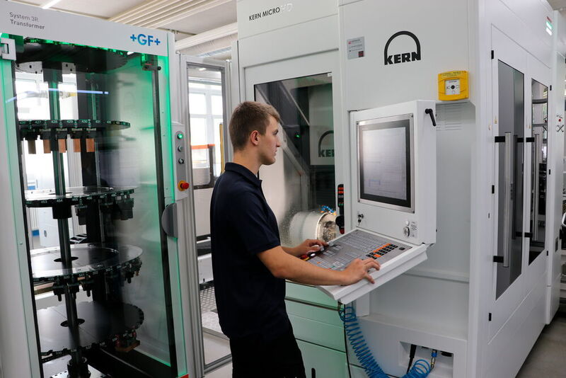Polytechnician Sascha Hämmerli only has to enter a few codes on the automated Kern Micro HD and immediately the five-axes milling center is producing parts like graphite electrodes and carbide cores in serial production – without operators and without any rejects.  (Kern Microtechnik)