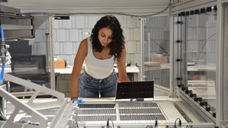 Die Projektleiterin am Fraunhofer ISE, Najwa Abdel Latif kontrolliert die verschalteten Solarzellen am Schindel-Matrix-Stringer des Fraunhofer ISE. (Bild: Fraunhofer ISE / Sophia Bächle)