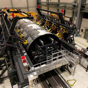 The MultiFAL assembly research platform with scaffolded thermoplastic fuselage shells of the MFFD. The yellow hexapod robots for holding and high-precision adjusting of shape and position of the upper shell are clearly visible.(Image: Fraunhofer IFAM)