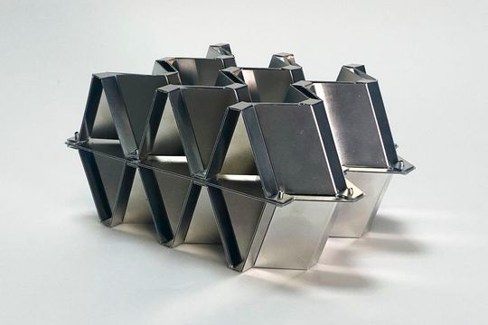 Ihren Einsatz könnte die Kirigami-Technologie in Kernschichten von Sandwichmaterialien finden. Die Ober- und Unterschicht kann, wie hier zur Demonstration in der Mitte zu sehen, verschraubt oder genietet werden.(Bild:  MIT)