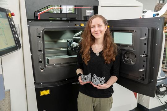 Maschinenbau-Studentin Viktoria Sobkowicz hat in ihrer Bachelorarbeit Bremssättel am Metall-3D-Drucker im Labor für Werkzeugmaschinen und Fertigungstechnik produziert. Diese werden für die E-Rennwagen des Formula-Student-Teams Racing Power Münster der FH Münster, dem die Studentin angehört, und für das Team der Technischen Universität Hamburg verwendet.(Bild:  FH Münster/Frederik Tebbe)