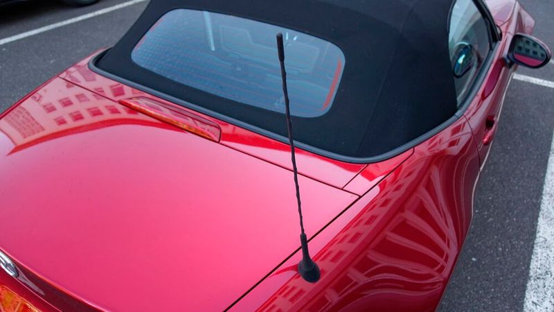 6. Die Antenne : … nichts. Die Riesenpeitsche auf dem rechten hinteren Kotflügel ruft geradezu nach einem Fuchsschwanz. Bitte nicht! Doch Musikhören macht im MX-5 ohnehin keinen großen Spaß, trotz der im Testwagen verbauten Bose-Anlage mit Kopfstützenlautsprechern und Fahrgeräuschkompensation. Lieber auf das Lied des Motors hören. (Bild: Rosenow – »kfz-betrieb«)