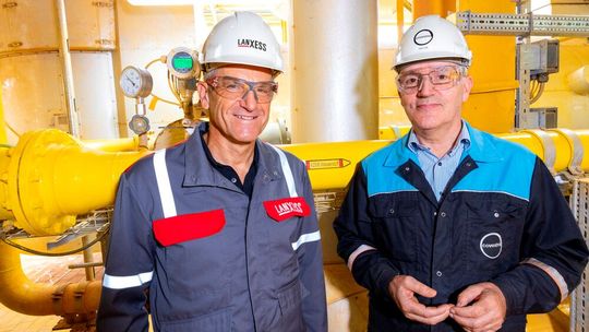 Michael Ertl, Leiter des Lanxess Geschäftsbereichs Inorganic Pigments, und Rob Eek, Produktionsleiter bei Covestro in Krefeld-Uerdingen, stehen vor der neuen Wasserstoffleitung, die die Anlage für Eisenoxide von Lanxess versorgt.   (Bild:  Lanxess)