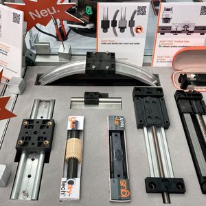 Bei Igus gab es sehr viele Neuheiten zu sehen, beispielsweise die Drylin-Econ-Schlitten (oben). Sie sind für leichte Verstell- und Positionieraufgaben geeignet und werden aus regranuliertem Kunststoff spritzgegossen, was sie besonders kostengünstig und nachhaltig macht. Anwender können sie beispielsweise in Ausgabeautomaten für Süßigkeiten einbauen, statt der momentan häufig verwendeten Aluminiumschlitten mit Gleitfolie. Das verringere die Kosten um bis zu 80 Prozent, erklärte Pressesprecher Oliver Cyrus. (Bild:  dm)