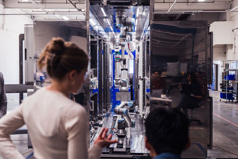 Wissenschaftlerin vor dem robotergestützten Bioproduktionssystem (Bild: Universal Robots)