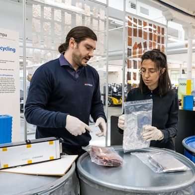 Nora Bartolomé (Empa) und Olivier Groux (Kyburz Schweiz AG) arbeiten zusammen an der Rückgewinnung von hochwertigen Rohstoffen aus Lithium-Ionen-Batterien.  (Bild: Innosuisse.)