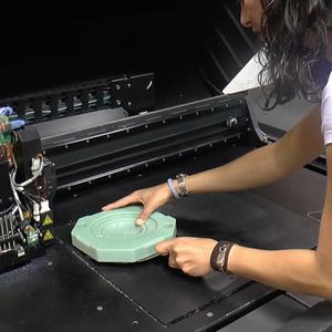A worker removes a plastic injection mould for a diaphragm from a multi-material 3D printer, which has saved time and costs at the Northern Irish shop.