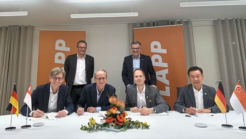 Vertragsunterzeichnung - Von links für die Jebsen & Jessen Gruppe: Per Magnusson, Group CEO, Viktor Leendertz, Group CFO (stehend), Heinrich Jessen, Group Chairman. Für die Lapp Gruppe: Matthias Lapp, Group CEO, Jan Ciliax, Group CFO (stehend), Richard Lee, Asia Pacific CEO, bei der Vertragsunterzeichnung. (Bild:  Lapp)