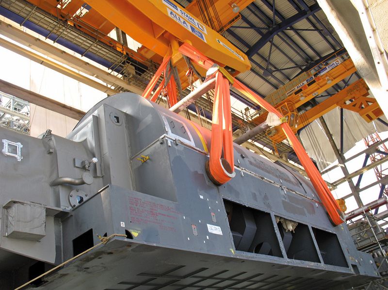 Bild 3: Schwere Fracht: Zum Heben der Generatoren werden zwei der Krane in Tandembetrieb geschaltet, die Lastaufnahme erfolgt per Spezialtraverse. (Bild: Stahl Cranesystems)