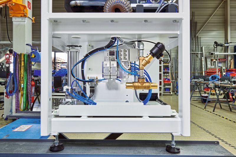 La communication via Ethercat/ PROFINET permet une commande particulièrement précise et complète du vérin Air Servo (à gauche de l'armoire de commande) à l'aide du contrôleur (au milieu de  l'armoire de  commande).  (Source : SMC Allemagne)