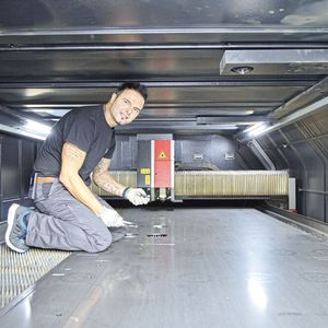 Rafet Osmani (Lasermaschinist, Fertigungs-Center Zumbrunn AG) im Maschinenraum (4000 x 2000 mm) der Flachbettlasermaschine der «Ventis AJ e»-Serie mit 9 kW für den Schwarzblechbereich. Die Schnittflächen sind qualitativ hochwertig, nicht zuletzt dank der LBC-Technologie von Amada.(Bild:  Matthias Böhm)