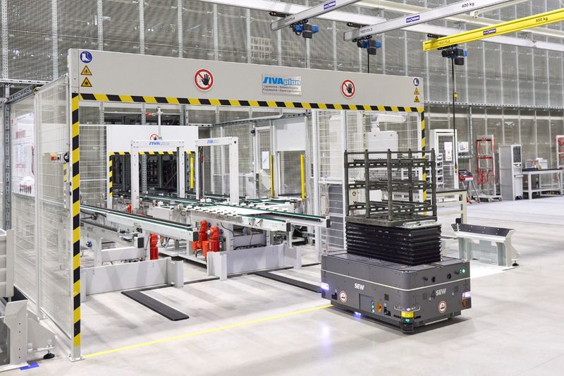 An vier Materialübergabestationen liefern mobile Roboter die produzierten Zahnräder und Wellen aus der Fertigung an. Diese werden im Logistikmodul von SEW Eurodrive zwischengelagert und anschließend in speziellen Öfen gehärtet.(Bild:  Leuze)