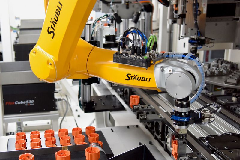 Der erste der sechs verbauten TX2-60L beim Einlegen eines Steckergehäuses in den Werkstückträger. (Ralf Högel | STÄUBLI TEC-SYSTEMS)