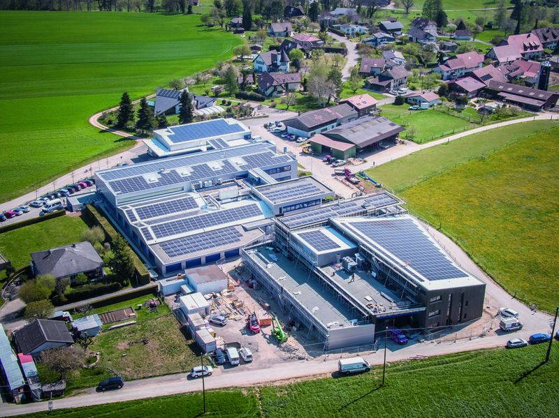 Le site de Recomatic à Courtedoux dans le Jura. L'entreprise produit 40 % de ses besoins en électricité grâce aux nombreux panneaux solaires installés sur les toits de ses bâtiments.   (Bild: Groupe Recomatic)