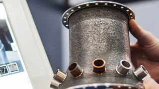 Per Laser gesintertes Hochleistungsbauteil aus einer herkömmlich nur schwer zu bearbeitenden Metalllegierung, fix und fertig mit Anschlusskomponenten und Lochkränzen zur Montage. (Messe Stuttgart)