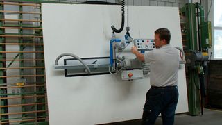 Eine Grossformatplatte wird vom Stapler angehoben, um 90° gekippt und für den Zuschnitt zur Vertikalsäge gefahren. Alle Vorgänge lassen sich einfach und sicher an der ergonomischen Zweihandbedienung steuern. (GIS)