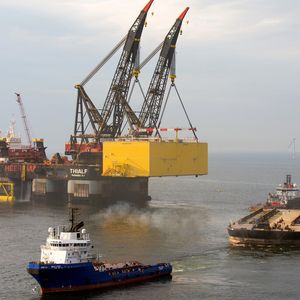 Mit dem Schwerlast-Kranschiff Thialf wird die Helwin2-Plattform von der Transport-Barge angehoben und dann auf die vorbereitete tragende Unterkonstruktion gehievt.