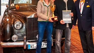 Das Siegerbild: Karl Rolf Muth (Mitte) mit seiner Gattin Ursula sowie Rennlegende 
und Jurymitglied Jochen Mass. Im Hintergrund das Siegerfahrzeug Rolls-Royce Silver Cloud II von 1962. (Auktion & Markt)