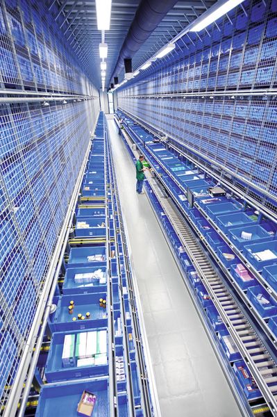 Im neuen Distributionszentrum von Salus entnehmen die Mitarbeiter, geführt von integrierten Pick-by-Light-Systemen, die entsprechenden Auftragsposten und kommissionieren sie direkt in die Versandbehälter. (Bild: SSI Schäfer)