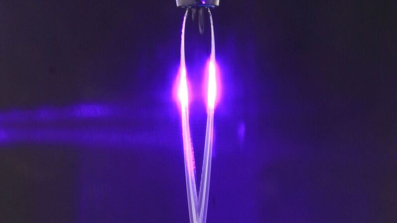 Bei diesem neuen Ansatz von Forschenden der Ruhr-Universität Bochum wird mit Natriumiodid-Ionen versetztes Wasser durch eine Düse aufgefächert. Dann wird ein kurzer Laserpuls hindurchgeleitet. In dieser Zeit wird die wässrige Lösung leitend.(Bild:  Adrian Buchmann)