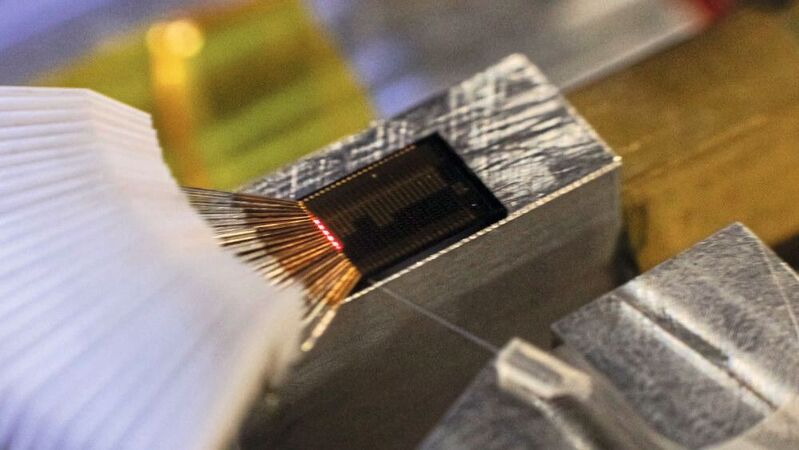 Photonik-Chips: Laserlicht leuchtet auf der Oberfläche eines photonischen Chips.