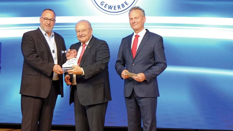 Einen Sonder-Kalligraphen überreichte ZDK-Präsident Jürgen Karpinski (M.) und ZDK-Vorstand Arne Joswig (r.) an Michael Neuburger, Pressesprecher der Innung Gifhorn, für sein Projekt „Werkstatthilfe für Geflüchtete aus der Ukraine“.  (Bild: Zietz – »kfz-betrieb«)