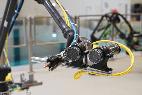 Das Bild zeigt Schweißbrenner und Stereokameras am Roboter-Endeffektor bei Versuchsvorbereitungen in der maritimen Explorationshalle des DFKI Bremen.(Bild:  Christian Koch / DFKI)