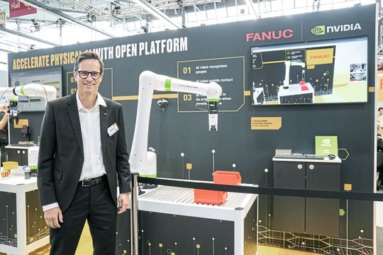 Dr. Philipp Dreiss, Head of Technics der Fanuc Deutschland GmbH, auf der AMB 2026. Im Hintergrund ist der kollaborative Roboter «Fanuc CRX» zu sehen, der mithilfe generativer KI-Technologie per Text- oder Sprachbefehl programmiert werden kann. Dieser Ansatz reduziert die Komplexität der Programmierung und senkt die Einstiegshürden für den Einsatz von Automatisierung.(Bild:  Nastassja Neumaier)