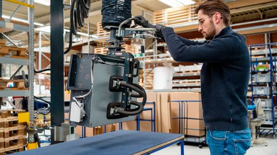 Ergonomische Palettierung: Der „heavyLIFT 80 kg“ mit einem Seitenlifter hebt den Gebläsekonvektor vom Prüftisch und ermöglicht das sichere Umsetzen auf Palette oder Rollenbahn.(Bild:  Timmer)