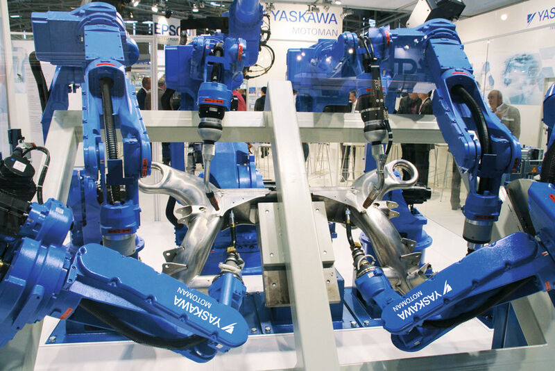 Sieben Yaskawa-Motoman-Roboter kooperieren in einer Showzelle am Messestand. Als integrierte Multi-Robot-Lösung sind sie durch eine einzige gemeinsame Steuerung gekoppelt. (Bild: Yaskawa)