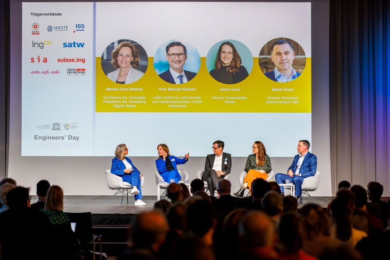 Am Engineers' Day Netzwerkanlass 2025 diskutierten Vertreter:innen aus Politik, Wirtschaft und Forschung. Auf dem Podium: Moderatorin Sonja Hasler, Monica Duca Widmer, EcoRisana SA, Michael Kleinert, ZHAW, Jenny Kunz, Ricola, Martin Rufer, SBV (v.l.n.r.). (Bild: Engineers' Day)
