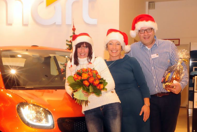 Schöne Bescherung: Kundin Anette Fröhlinger (li.) posiert mit Katrin Heinig und Sascha Vogel vom Smart-Center Saarbrücken vor ihrem vorzeitigen Weihnachts-Geschenk. (Wolfgang Klauke)