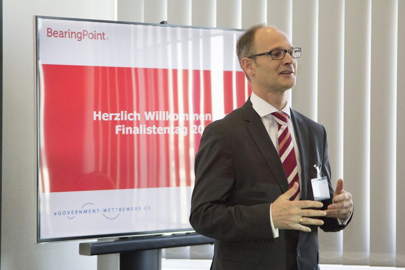 Jon Abele begrüßt die Gäste, Teilnehmer und die Jury des Finalistentags (Bild: Bearingpoint)