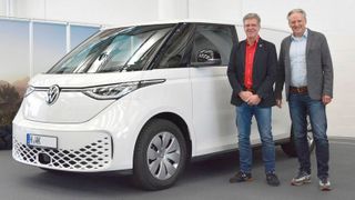 Der erste „ID.Buzz Cargo“ wurde in schlichtem Weiß ausgeliefert. Der Premierenkunde Wolfgang-Nils Kempe (links) und Thomas Schulz, Neuwagen-Verkaufsleiter bei VWN, bei der Übergabe im Kundencenter des VWN-Werks in Hannover. (Bild: Volkswagen Nutzfahrzeuge)