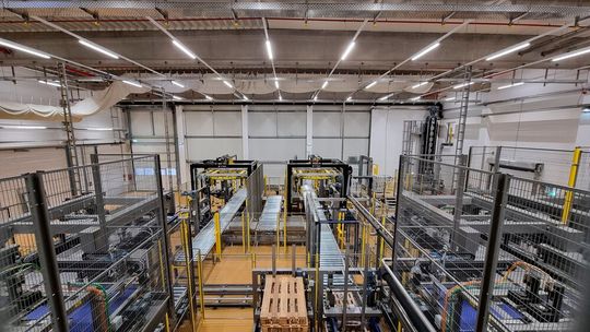 Das technische Highlight bei Nordseemilch ist die automatische End-of-Line-Abwicklung mit Hocheinlaufpalettierer (vorne) und Wicklung (hinten, Mitte).(Bild:  Vialog)