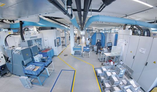 Blick auf die beiden Fertigungsinseln (je eine links und rechts), die jeweils über zwei Heller «HF 3500» sowie über je eine flexible Goodj-Automation verfügen. Die Anlage ist dermassen perfektionistisch ausgelegt, dass alle vier Heller-Bearbeitungszentren auf über 7000 h Produktionszeit pro Jahr kommen.(Bild:  Matthias Böhm)
